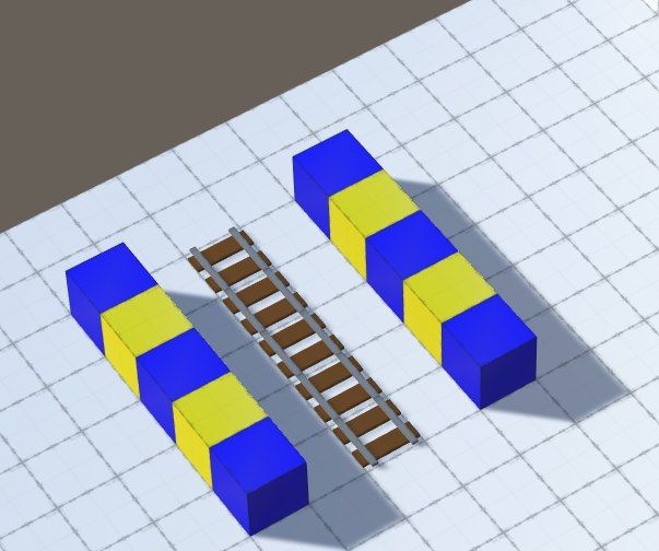 Screenshot of a set of rails next to blue and yellow prototype blocks, on a white floor.